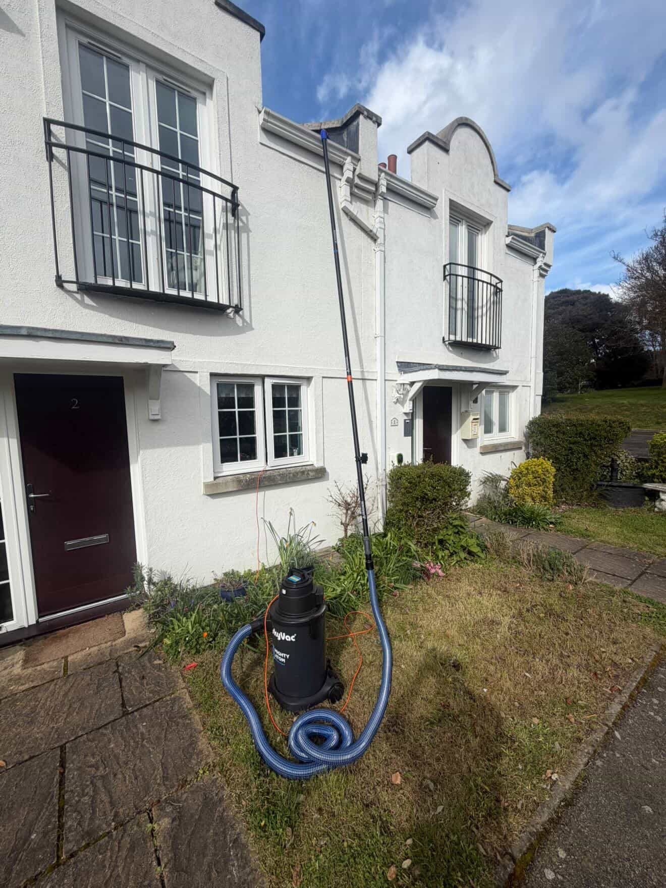 External cleaning work in progress on white cottage