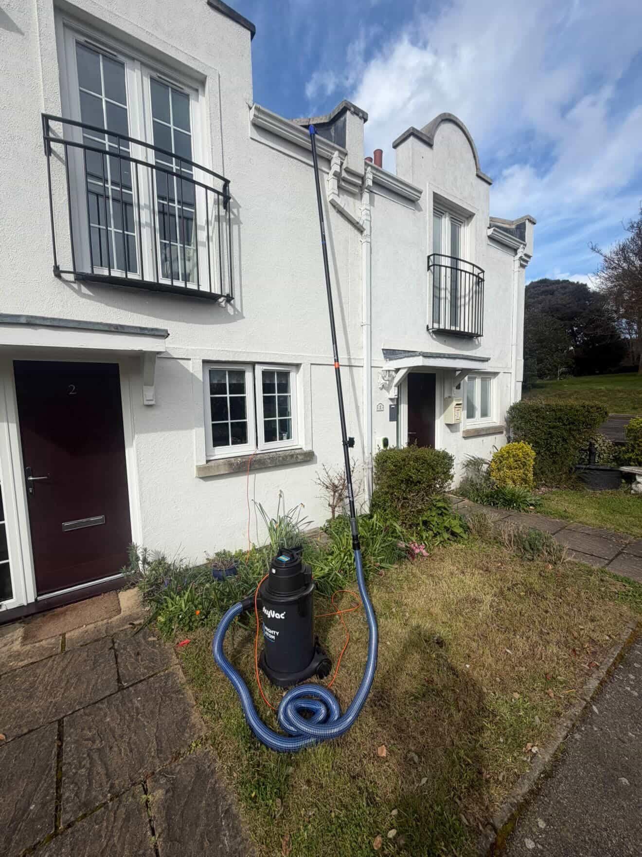 External cleaning equipment positioned outside white residential property